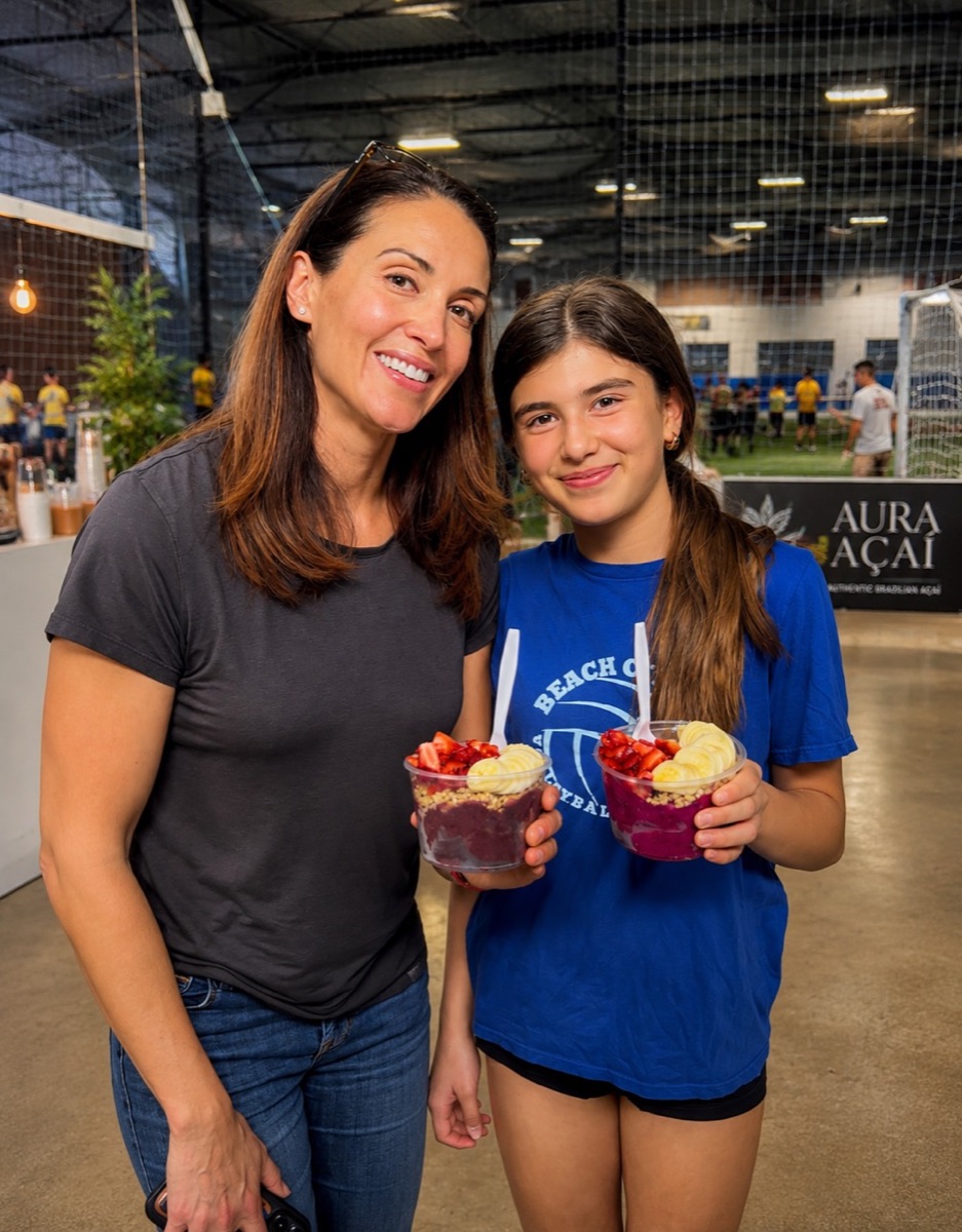 Los Angeles event guests holding fresh Aura Açaí bowls with banana and strawberries