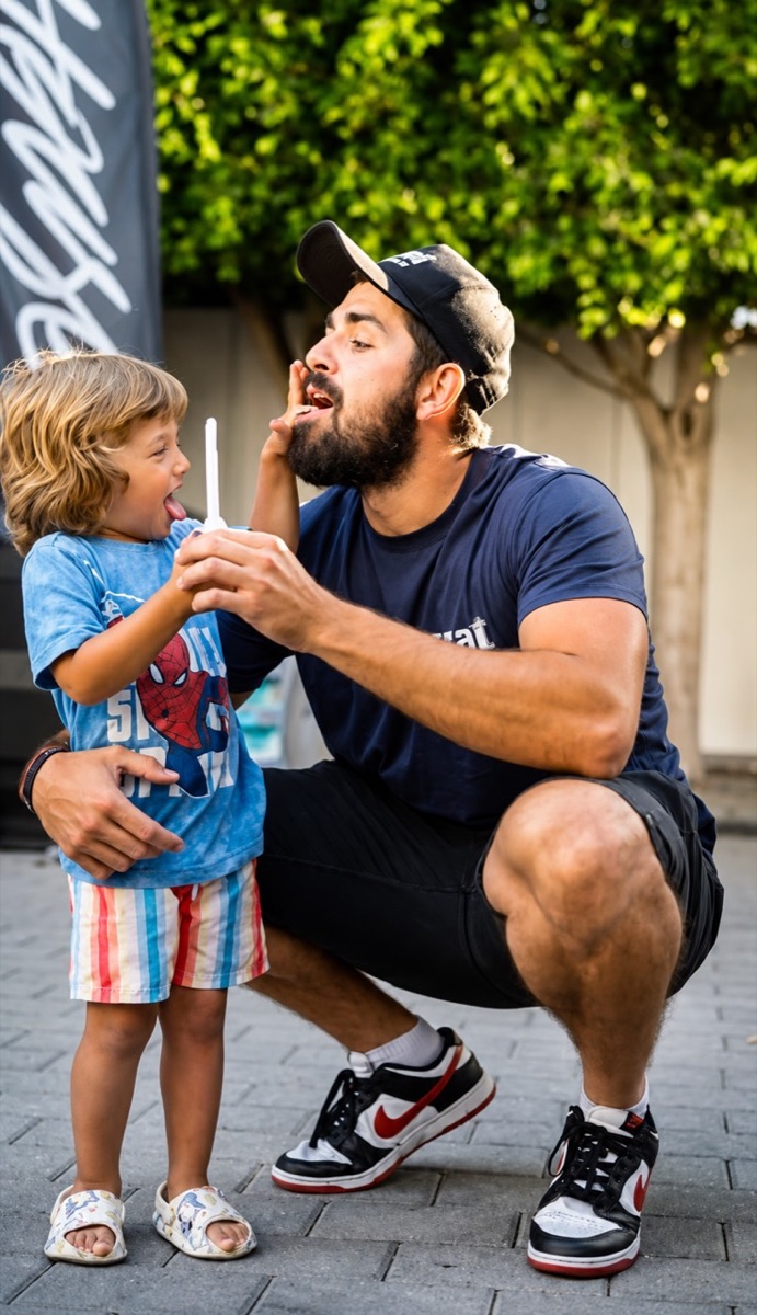 Father and child sharing a playful Aura Açaí moment at an outdoor Los Angeles event